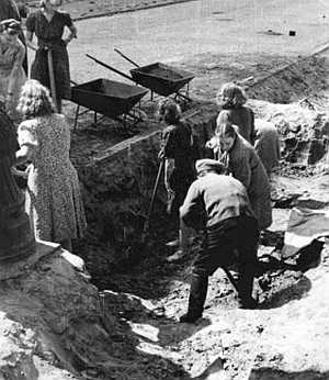 LUDNOŚĆ CYWILNA POMAGA w BUDOWIE BARYKADY NIEPODAL KAMIENICY przy ULICY ZGODA 1: LOKAJSKI, Eugeniusz (1908, Warszawa - 1944, Warszawa), połowa sierpnia 1944; źródło: fototeka.1944.pl